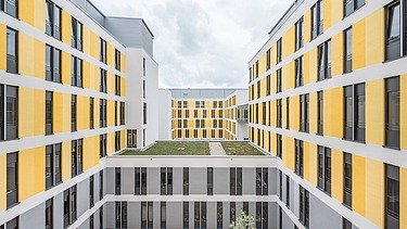 Innenhof des Universitätsklinikums Jena mit gelber Fassade