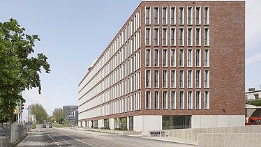 Blick auf das Bürotel mit Tiefgarageneinfahrt und dem Karlsruher Hauptbahnhof im Hintergrund