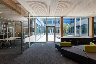 Innenaufnahme des Paul-Klee-Gymnasiums in Gersthofen. Man sieht eine Holz-Pfosten-Riegel-Fensterfassade.