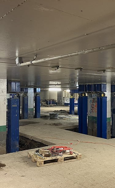 Foto von blauen Verstärkungsmaßnahmen neben Stützen