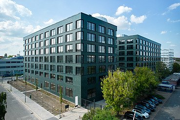 Exterior view of the INK Inspire Neukölln in Berlin with striking green façade