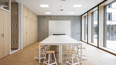 Innenaufnahme der Vinzenz-Pallotti-Schule in Friedberg. Man sieht einen möblierten Besprechungsraum und eine  Holz-Pfosten-Riegel-Fassade.