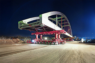Foto des Transports der Stabbogenbrücke über die A100 mittels SPMT bei Nacht