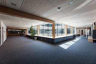 Innenaufnahme des Paul-Klee-Gymnasiums in Gersthofen. Man sieht eine Holz-Pfosten-Riegel-Fensterfassade.