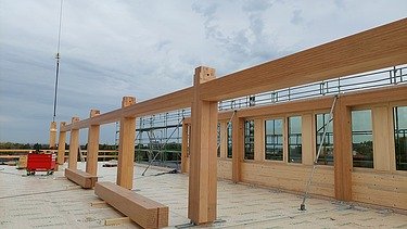 Foto der Montage des UmweltHauses in Nürnberg. Man sieht Holzelemente.