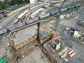 Aerial view of a construction site with railroad line and underpass