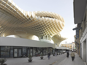 Foto des Marktplatzes mit Einkaufsarea in Sevilla Spanien. Man sieht pilzartige Holzkonstruktionen.