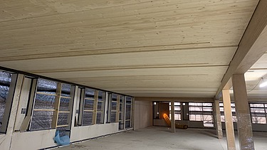 Foto des Rohbaus des Paul-Klee-Gymnasium in Gersthofen. Man sieht eine Holzdecke von unten.