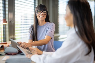 Zwei Angestellte im Büro, die sich besprechen