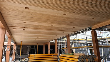 Foto des Rohbaus des Paul-Klee-Gymnasium in Gersthofen. Man sieht eine Holzdecke.