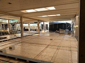 Foto des Rohbaus des Paul-Klee-Gymnasium in Gersthofen. Man sieht viele Holzoberflächen im Innenraum.
